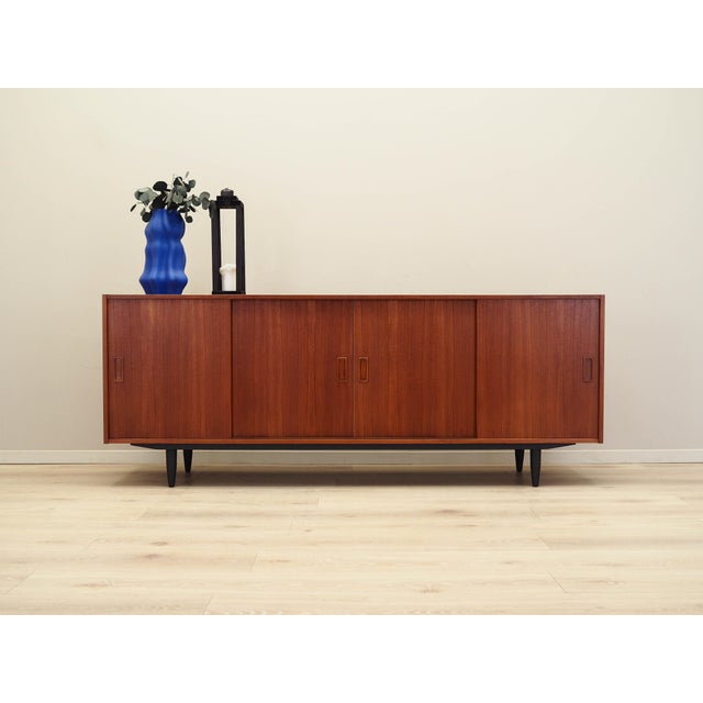 The sideboard was made in the 1970s, Danish production. The structure is covered with teak veneer. The legs are made of...