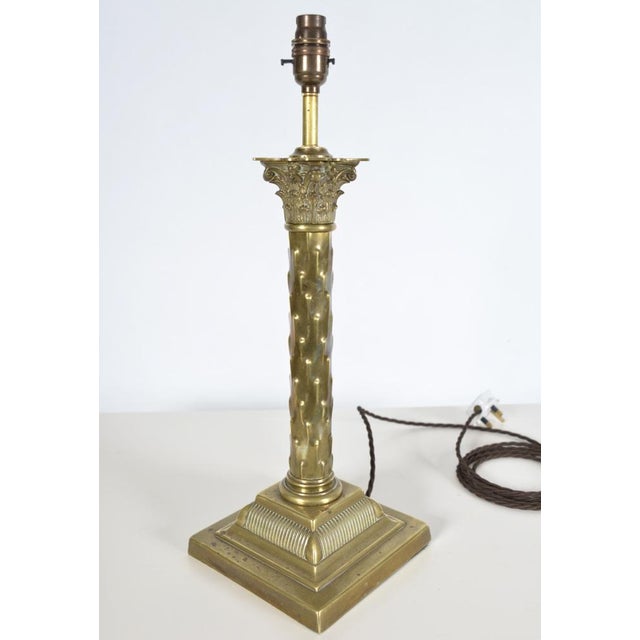 Lovely brass table lamp base in the shape of a Corinthian column, sitting on a stepped, fluted square plinth and topped...