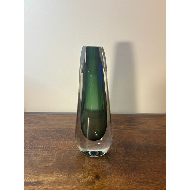 A beautifully executed hand blown art glass vase with thick, heavy walls and a rich green interior encased in clear...