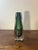 A beautifully executed hand blown art glass vase with thick, heavy walls and a rich green interior encased in clear...
