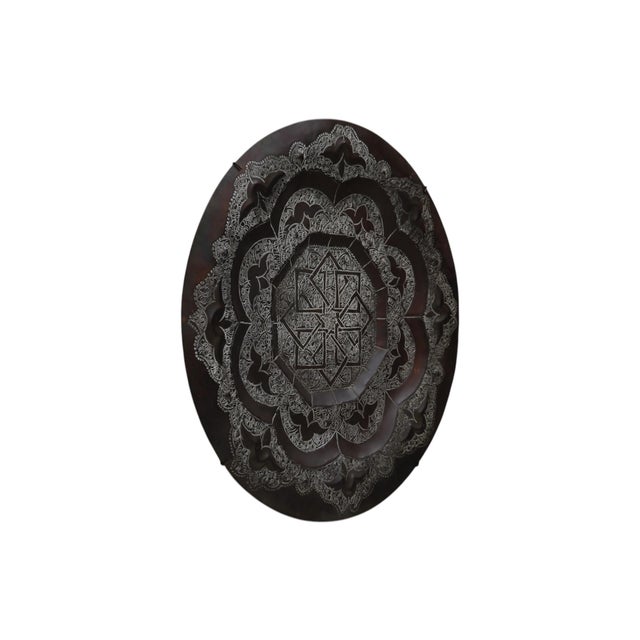 A decorative etched copper Persian charger plate. The octagonal center of the plate has a star motif made of eight...