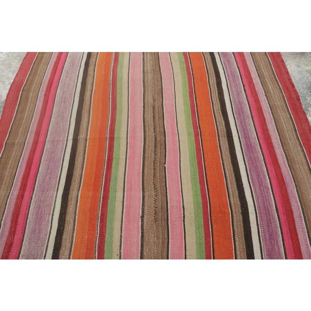 Handwoven in wool circa 1950–1960, this 5x5 vintage Kilim, woven in the tradition of a Frazada textile, is a vibrant and...
