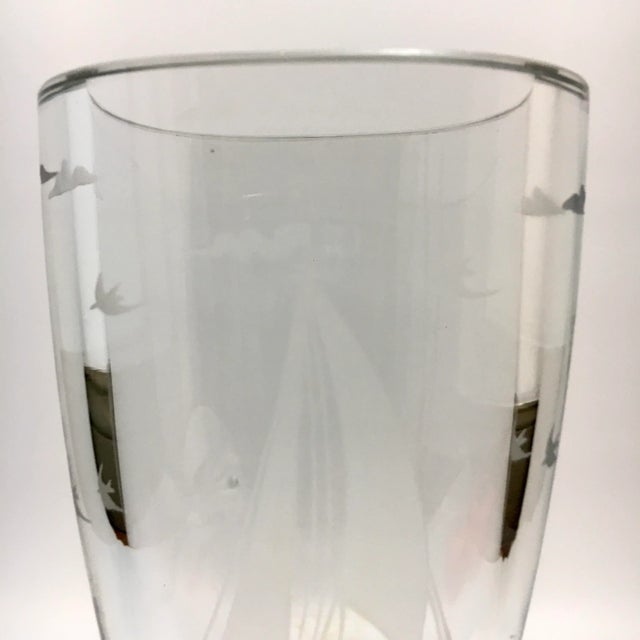 This crystal vase is etched with a sailboat at sea with gulls. Signed at base. Dimensions: 4.125” x 3.125” x 6.25” MCM...