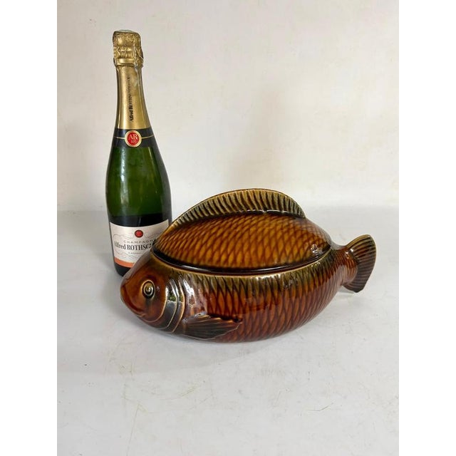 This fish-shaped trinket tray was made in France in the 1970s. It is made of glazed ceramic in beautiful shades of beige-...
