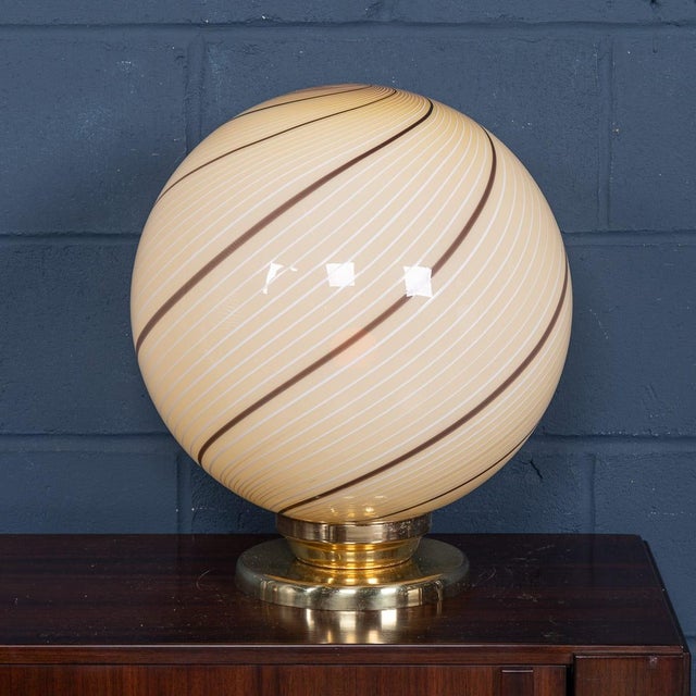 A striking murano glass globe table lamp, produced in venice, italy, circa 1980. The large spherical shade is beautifully...