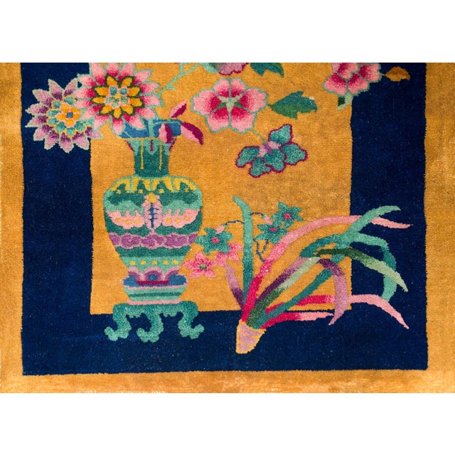 A sweet early 20th century Chinese Art Deco rug with a large vase in one corner, potted with multi-colored peonies,...