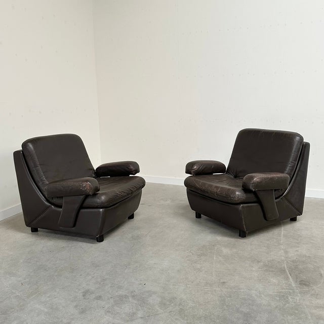 Two comfortable dark brown leather armchairs from the 1970s.