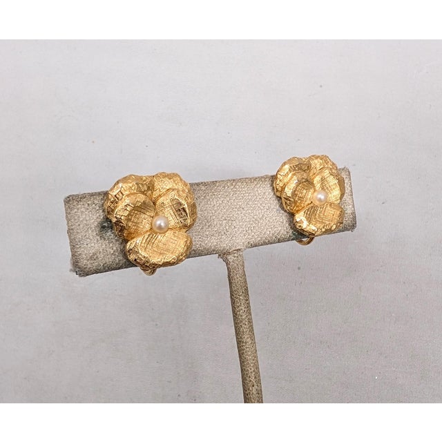 1960s textured goldtone pansy with faux-pearl center clip and adjustable screw back earrings. Marked "NAPIER©" on the...