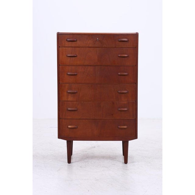 Vintage teak tallboy chest with six spacious drawers and a beautiful, continuous front panel. The slender legs and...