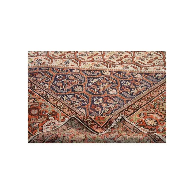 Handwoven Antique Persian Mahal rug featuring an intricate geometric motif on an ivory-colored field with navy corners and...