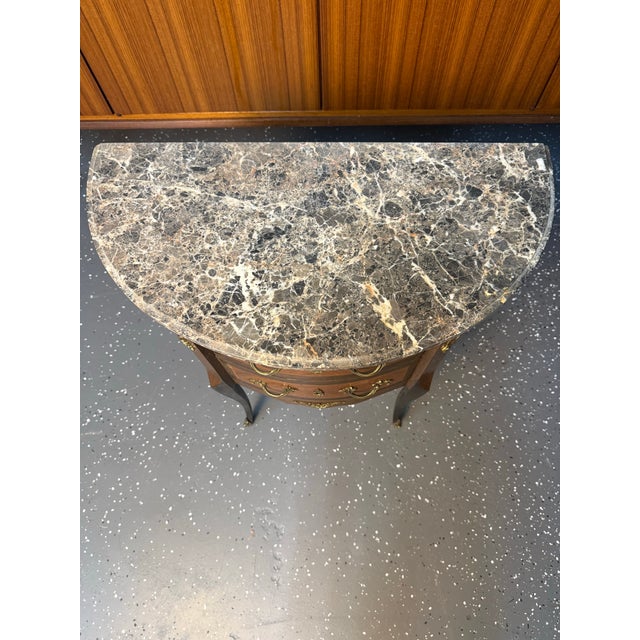 French Louis XVI grey marble top petite commode with book matched veneer with banding, brass sabots, and cast ormolu...