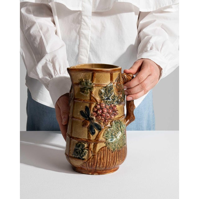 This 1900s barbotine ceramic jug from France is molded in barbotine with applied, trellised relief in honey, green and...