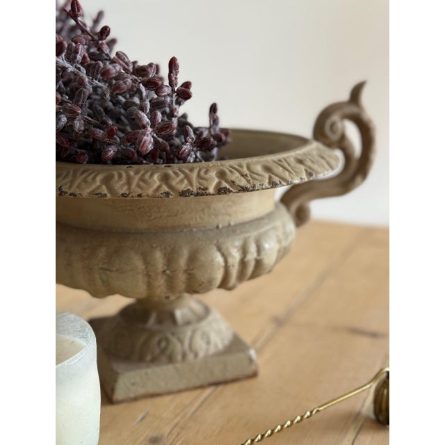 A cast iron French garden urn, the campana bowl edged in a band of leaf casting and flanked by a pair of scrolled handles,...
