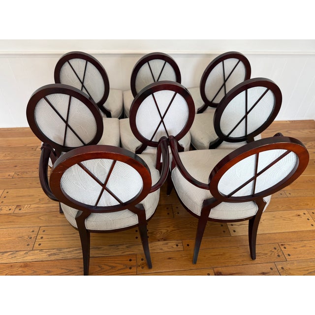Set of 8 dining chairs, including 2 armchairs. These elegant chairs feature refined oval backs, graceful curved arms, and...
