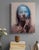 This oil on panel artwork presents a figure with a serene expression, partially obscured by a translucent blue visage that...