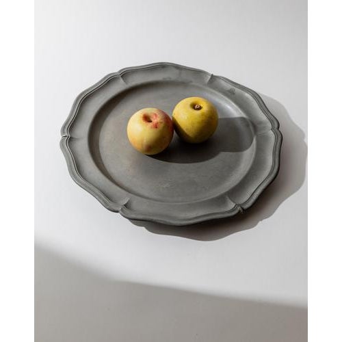 This vintage pewter wall plate from the 1940s features a gently curved rim with fine ribbed detailing, giving it a refined...