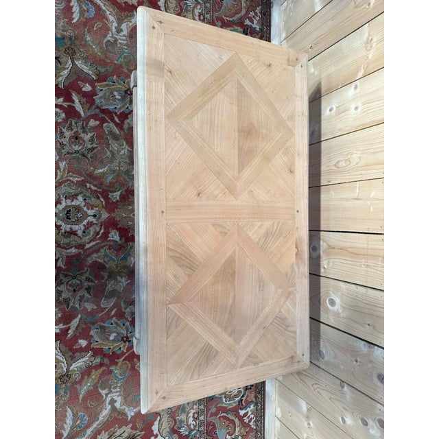 A louis xiii style coffee table in solid cherry wood, featuring a parquet top composed of pieces of wood arranged in...