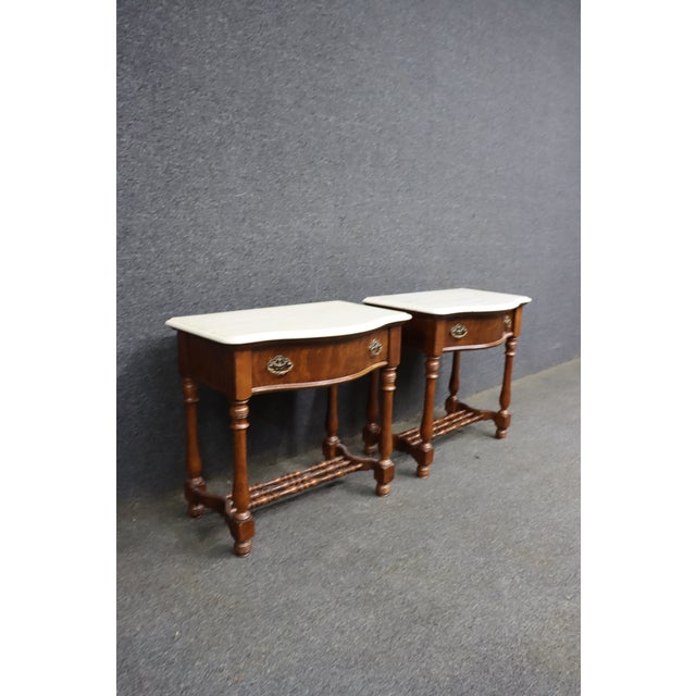 Pair of Pulaski Furniture Corporation oak nightstands with figured oak drawer fronts, shaped faux marble tops, ornate...