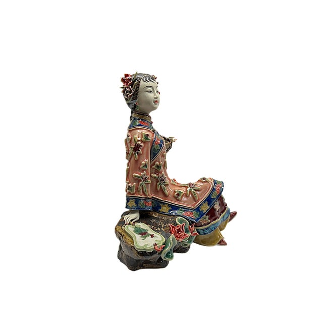 This exquisite porcelain figurine captures the serene beauty and grace of a lady in traditional Qing Dynasty attire....
