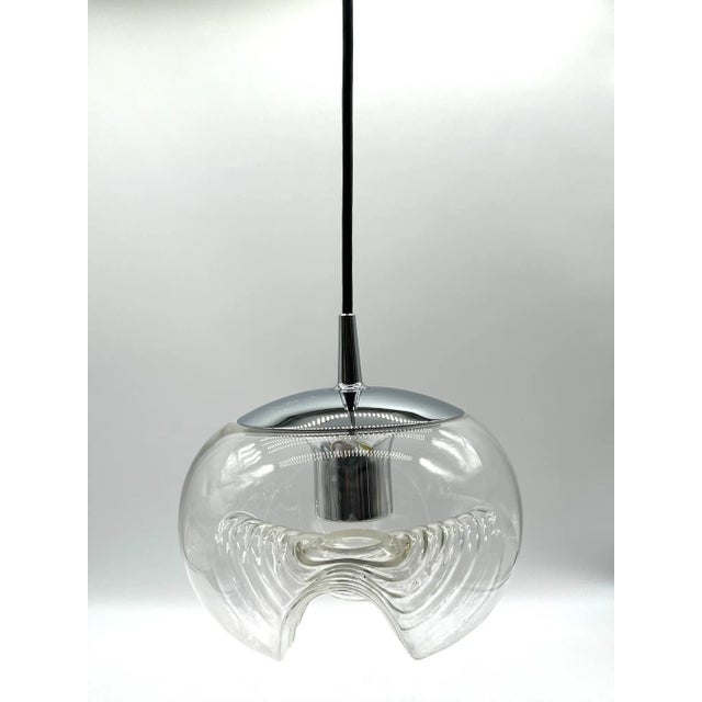 This elegant vintage pendant lamp combines an organically shaped, mouth-blown glass shade with a chrome-plated socket. The...