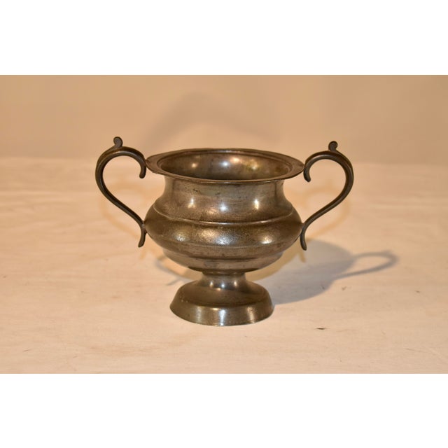 Early 19th century pewter urn from England. The form is la wonderfully bulbous shape with a handle on wither side which...