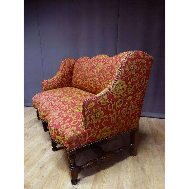 Large three seater winged sofa, Louis XIII period. The base with baluster and spacer (eight feet) is in turned walnut....