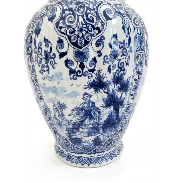 13” h x 8” diameter Dutch, 20th Century. Museum shop quality Delft ginger jar, fluted body joins an octagonal lid with a...