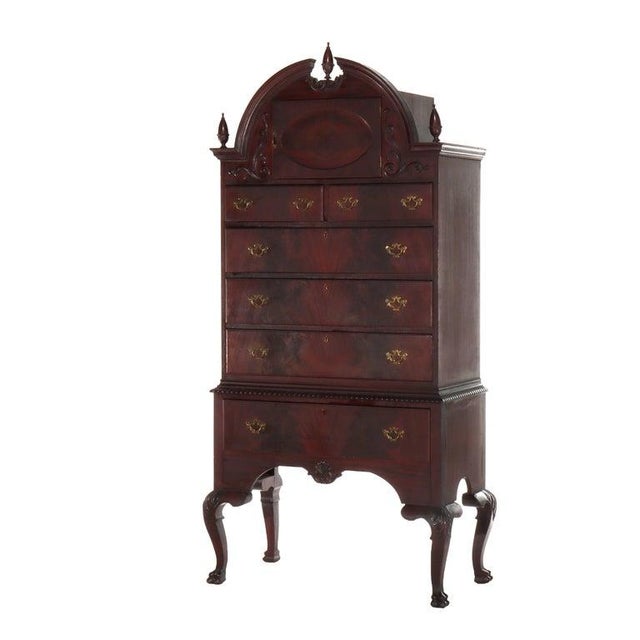 This fine antique Queen Anne style bonnet top highboy, crafted from rich mahogany, dates to approximately c1900. The piece...