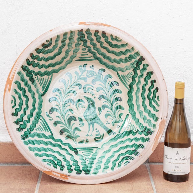 A Spanish Fajalauza lebrillo pottery bowl from Granada, hand-painted in green over a cream glaze, a large ceramic wall art...