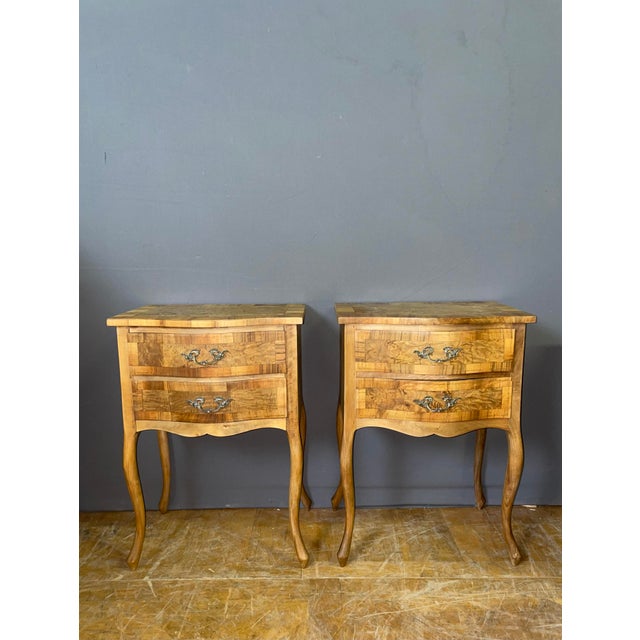 Pair of Italian bedside tables in walnut, ash, and cherry wood, each with two drawers and resting on four cabriole legs....