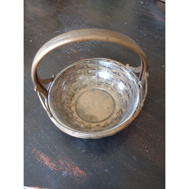 Offered is a pretty vintage woven, handled brass basket with a glass liner. It has a nice patina and extra detailing from...