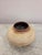 A sculptural ceramic vase by CB2 featuring a rounded silhouette, warm cream glaze, and subtle crackle-inspired texture....