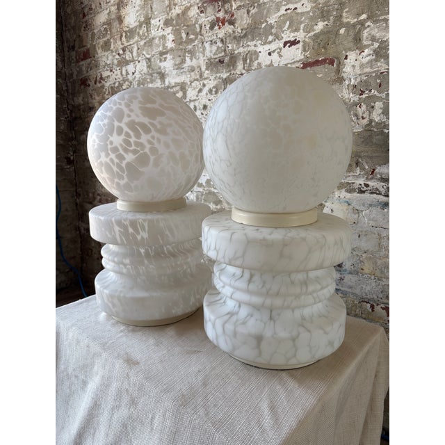 Striking pair of vintage Murano glass table lamps featuring handblown white cased glass with an organic clouded pattern...