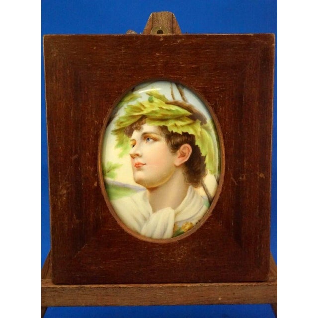 Delightful oval plaque in hard-paste porcelain, depicting the face of the god Apollo or Dionysus with the classic crown of...