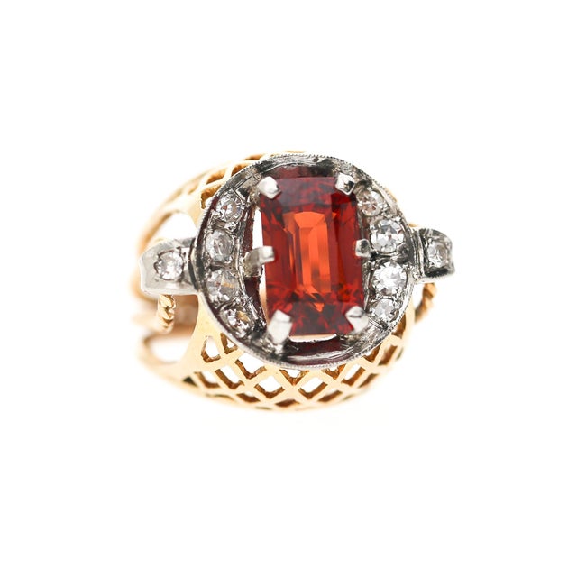 A bold 18K two-tone rose and white gold cocktail ring featuring a vivid 4.65 carat cushion-cut spessartine garnet center...