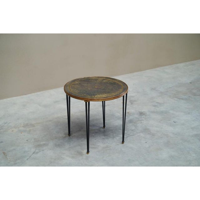 A wonderful and beautifully patinated side table in wrought iron, gilded metal and verre élogmisé. Most probably French,...
