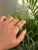 This solitaire bezel-set ring features a 1.64-carat natural oval-cut emerald set in 18K yellow gold. The emerald measures...