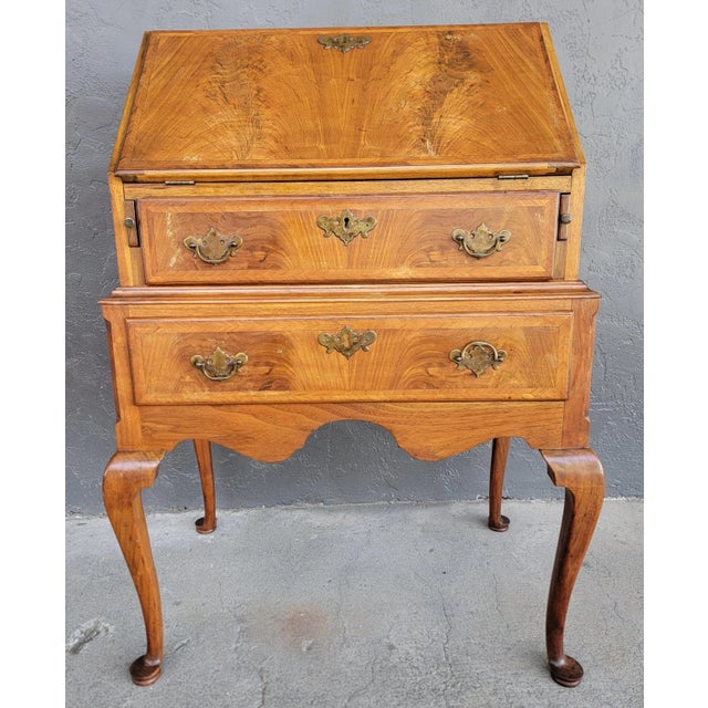 A 19th century Queen Anne secretary desk crafted in solid mahogany with flame mahogany detail. Fitted interior with pigeon...