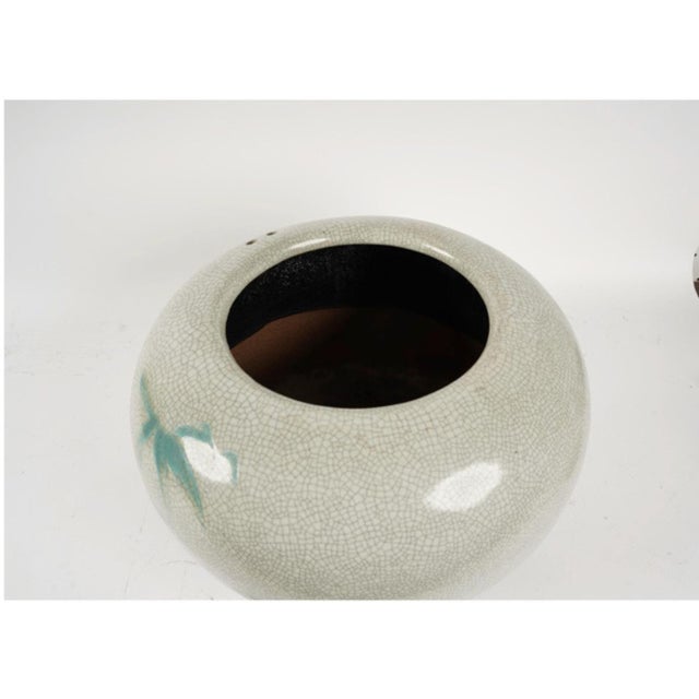 This is a large early 20th century Japanese crackled glazed celadon vessel that was most probably a Hibachi. The vessel is...