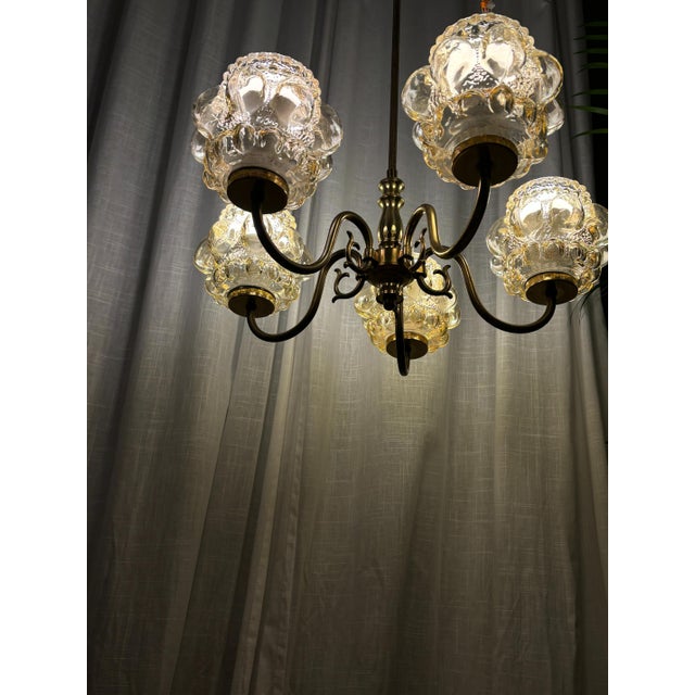 Hanging brass five-arm ceiling lamp, designed by Helena Tynnell, Glashütte Limburg, 1960s. The lamp is in near-perfect...