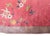 This vintage 1930s Chinese Art Deco rug features a vibrant red field with an elegant oval shape. The composition is...