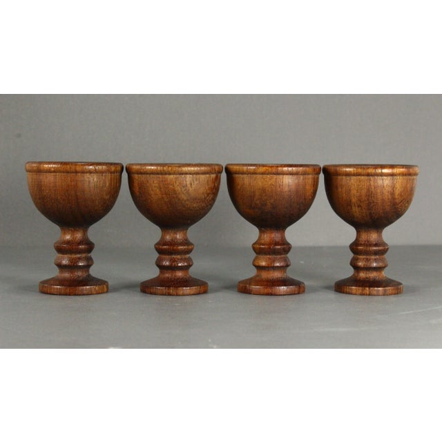 A beautiful set of four treen ware cups Finely crafted from turned exotic hard wood, raised on stems, most likely egg...