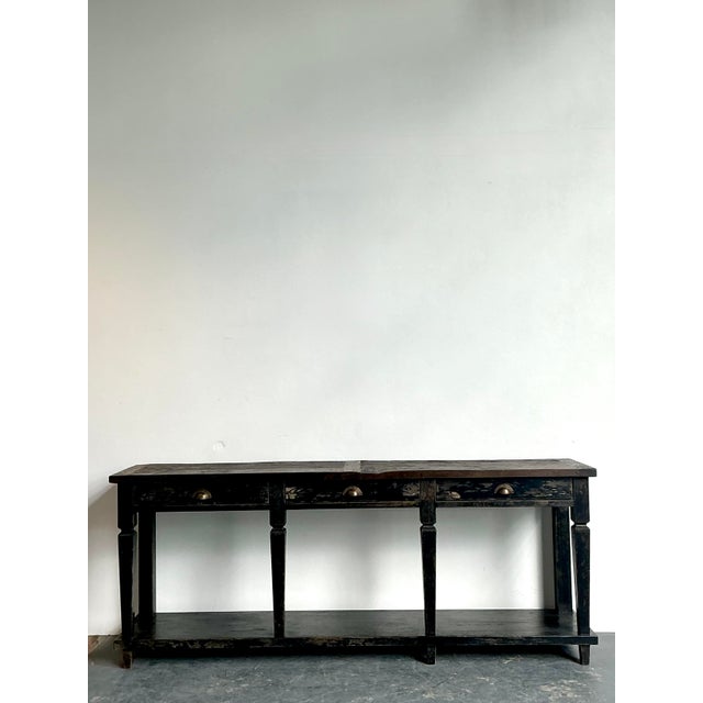 This monumental seven-foot console table is a masterclass in rustic industrial design and atmospheric texture. Expertly...