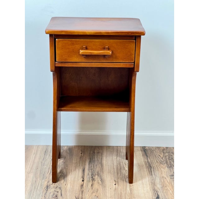 This vintage Mid-Century nightstand by Cushman epitomizes the sleek, practical design characteristic of the period....