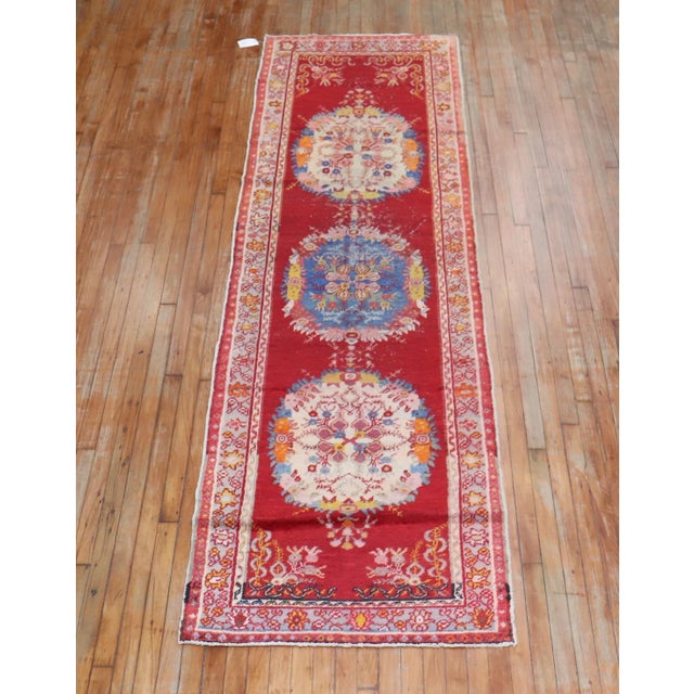 One of a kind, mid 20th-century Hand-knotted Turkish Wool Runner with 3 medallions on a bright red field. Professionally...