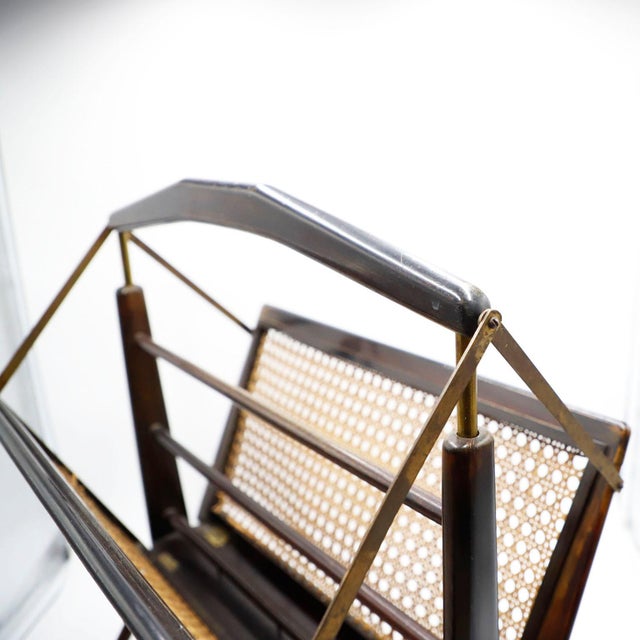 We offer this folding magazine rack in cedar wood and brass details, original paint and beautiful patina circa 1950.