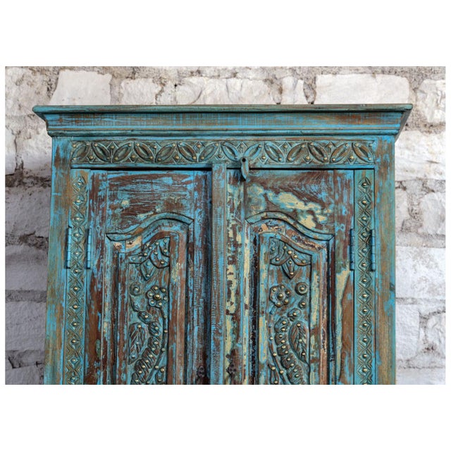 A captivating statement piece, this antique blue carved armoire brings together old-world artistry and rustic elegance....