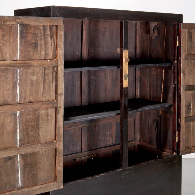 Chinese lacquered tall cabinet, dating to the early to mid-20th century. It is constructed from wood with a black lacquer...