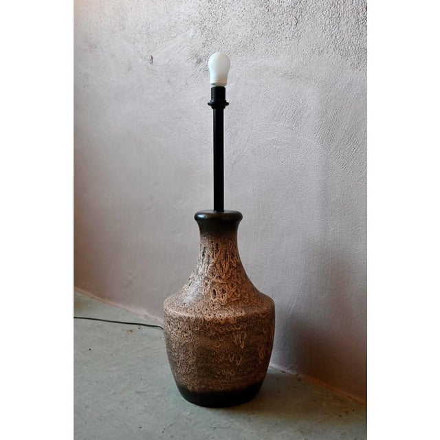 Imposing and organic, this floor lamp evokes the ceramic adventure of West Germany in the 1970s. Its stoneware body takes...