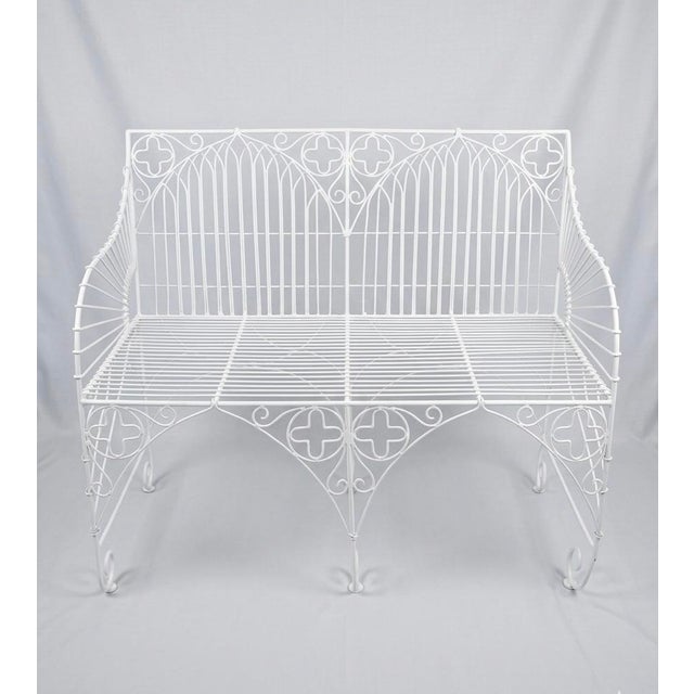 A stunning Gothic Revival style garden bench. Crafted from durable wrought iron and finished in a crisp white paint, this...